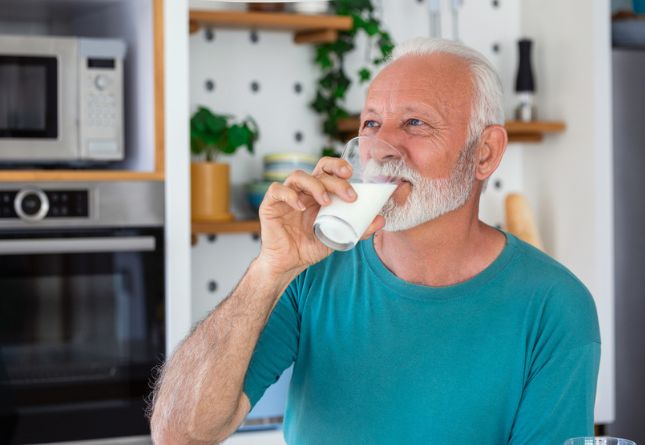 Homme âgé buvant un verre de lait